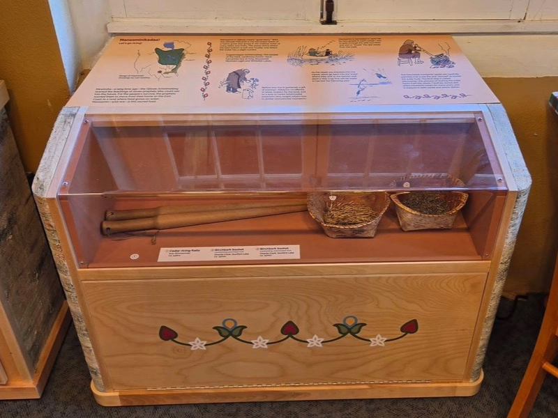 Traditional tools and woven baskets displayed with illustrated interpretive content