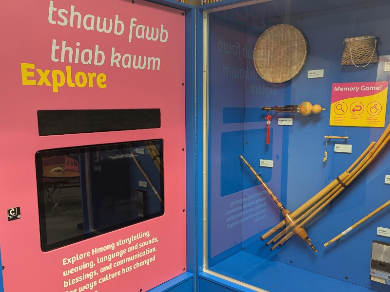 Interactive Hmong storytelling display with traditional instruments and a Capption indicator