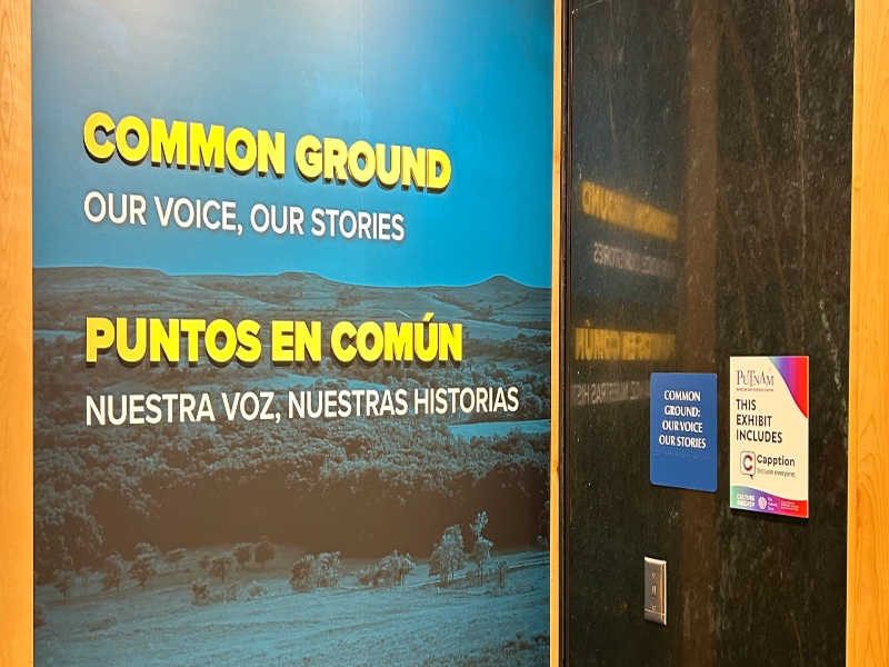 The bilingual entrance to the Common Ground exhibit displays its Capption access information