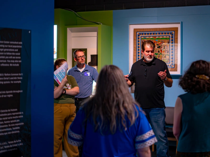 A guide speaks to visitors inside the Common Ground exhibit