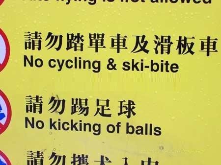 A sign with a machine-translation error reading: 'No cycling & ski-bite and No kicking of balls'